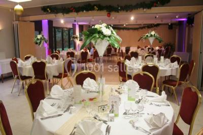 Assiette d'os à moelle avec pain grillé, verre de vin rouge et sel, posés sur une table avec une bouteille en arrière-plan.