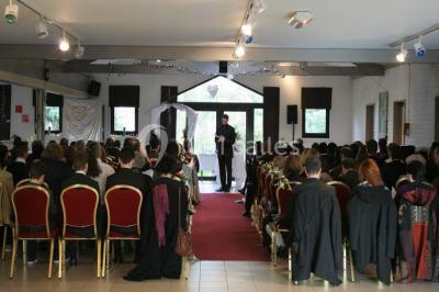 Assiette d'os à moelle avec pain grillé, verre de vin rouge et sel, posés sur une table avec une bouteille en arrière-plan.