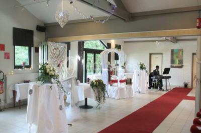 Assiette d'os à moelle avec pain grillé, verre de vin rouge et sel, posés sur une table avec une bouteille en arrière-plan.