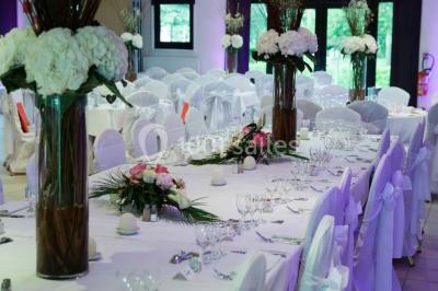 Assiette d'os à moelle avec pain grillé, verre de vin rouge et sel, posés sur une table avec une bouteille en arrière-plan.
