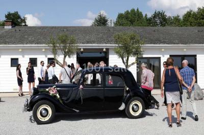 Assiette d'os à moelle avec pain grillé, verre de vin rouge et sel, posés sur une table avec une bouteille en arrière-plan.