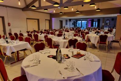 Assiette d'os à moelle avec pain grillé, verre de vin rouge et sel, posés sur une table avec une bouteille en arrière-plan.