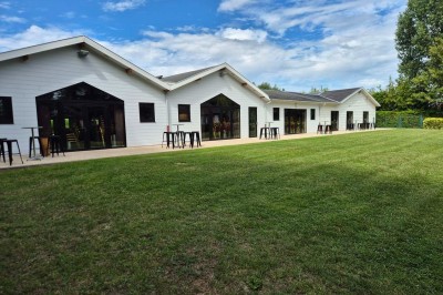 Assiette d'os à moelle avec pain grillé, verre de vin rouge et sel, posés sur une table avec une bouteille en arrière-plan.