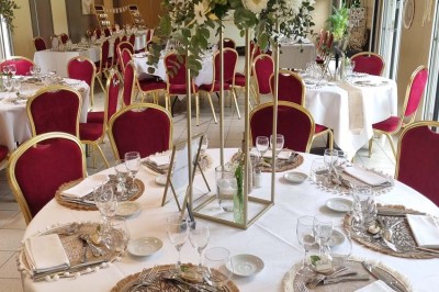 Assiette d'os à moelle avec pain grillé, verre de vin rouge et sel, posés sur une table avec une bouteille en arrière-plan.