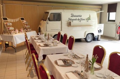 Assiette d'os à moelle avec pain grillé, verre de vin rouge et sel, posés sur une table avec une bouteille en arrière-plan.