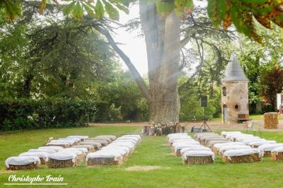 Façade d'une maison ancienne en pierre avec des fenêtres à petits carreaux, entourée de végétation.