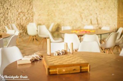 Façade d'une maison ancienne en pierre avec des fenêtres à petits carreaux, entourée de végétation.