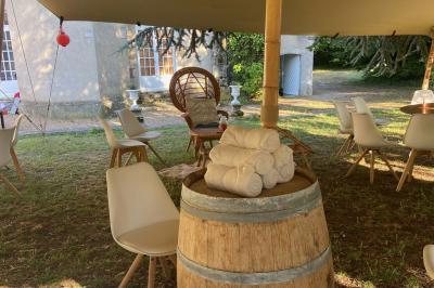 Façade d'une maison ancienne en pierre avec des fenêtres à petits carreaux, entourée de végétation.