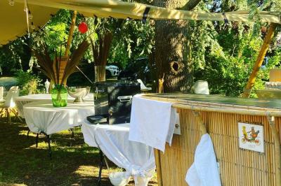 Façade d'une maison ancienne en pierre avec des fenêtres à petits carreaux, entourée de végétation.