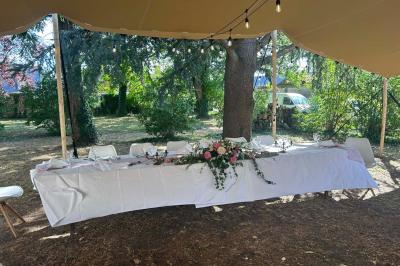 Façade d'une maison ancienne en pierre avec des fenêtres à petits carreaux, entourée de végétation.