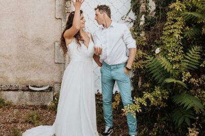 Façade d'une maison ancienne en pierre avec des fenêtres à petits carreaux, entourée de végétation.