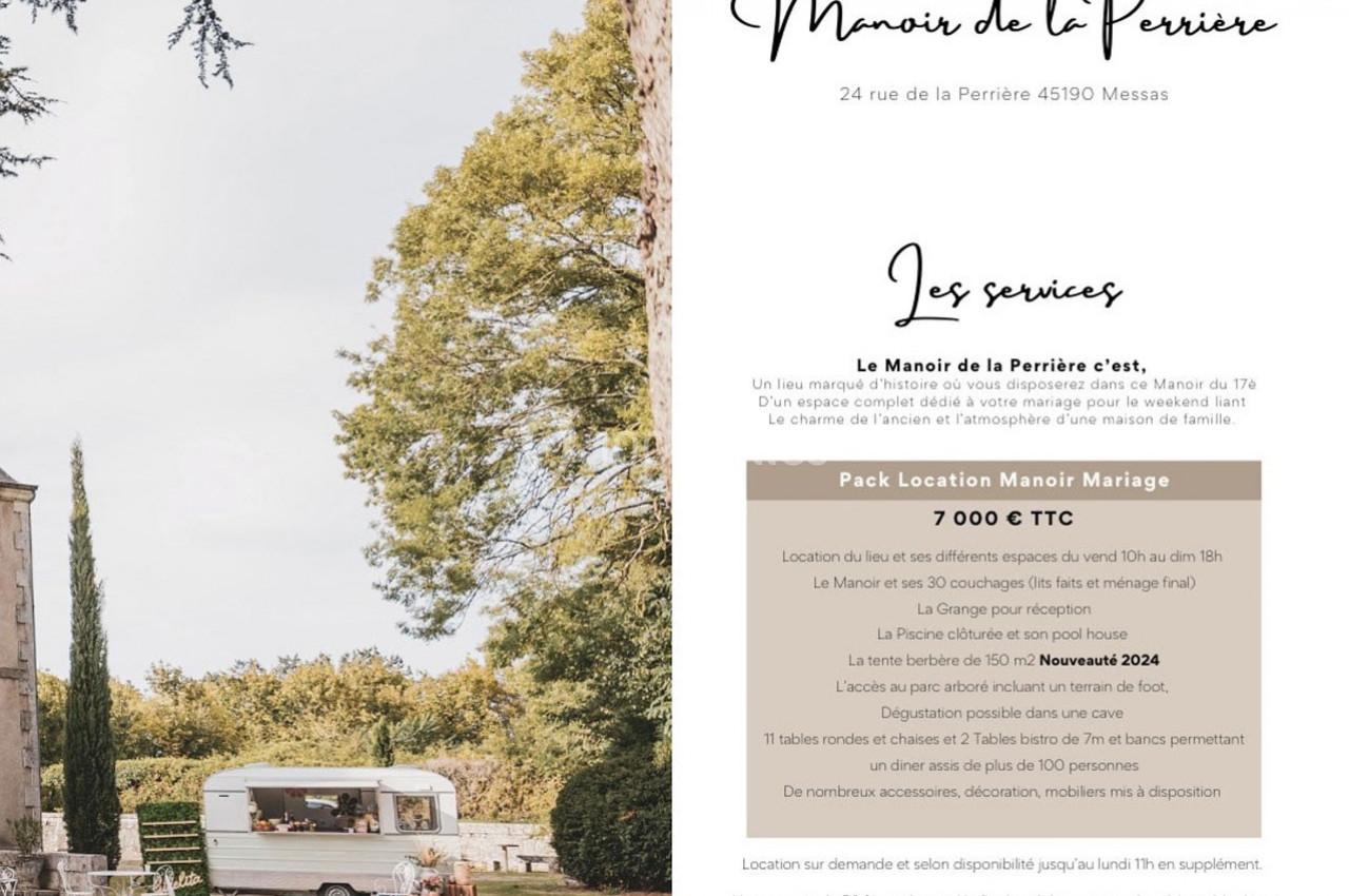 Une caravane vintage blanche stationnée dans un jardin avec des arbres et un bâtiment ancien en arrière-plan.