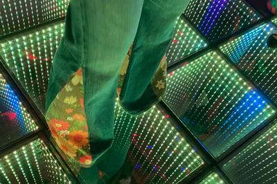 Façade d'une maison ancienne en pierre avec des fenêtres à petits carreaux, entourée de végétation.