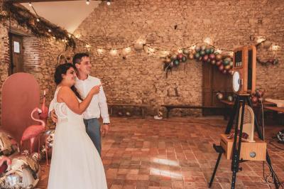 Façade d'une maison ancienne en pierre avec des fenêtres à petits carreaux, entourée de végétation.