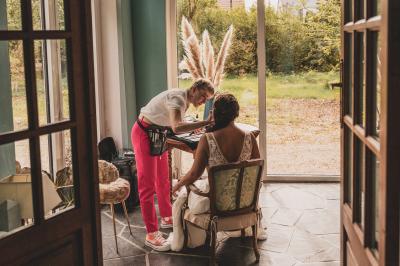 Façade d'une maison ancienne en pierre avec des fenêtres à petits carreaux, entourée de végétation.