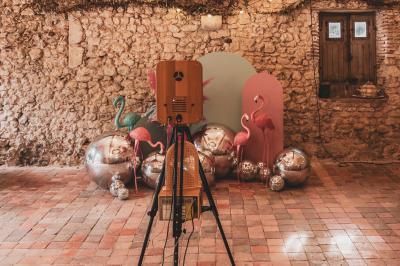 Façade d'une maison ancienne en pierre avec des fenêtres à petits carreaux, entourée de végétation.