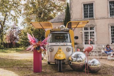 Façade d'une maison ancienne en pierre avec des fenêtres à petits carreaux, entourée de végétation.