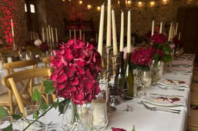 Façade d'une maison ancienne en pierre avec des fenêtres à petits carreaux, entourée de végétation.