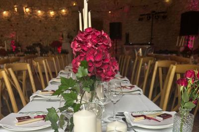 Façade d'une maison ancienne en pierre avec des fenêtres à petits carreaux, entourée de végétation.