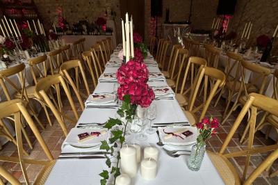 Façade d'une maison ancienne en pierre avec des fenêtres à petits carreaux, entourée de végétation.
