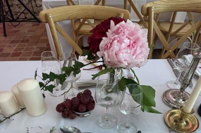Façade d'une maison ancienne en pierre avec des fenêtres à petits carreaux, entourée de végétation.