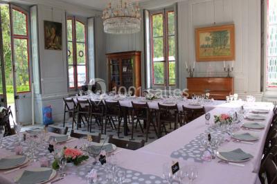 Façade d'un grand bâtiment ancien entouré de motos stationnées sur une pelouse et une allée gravillonnée.