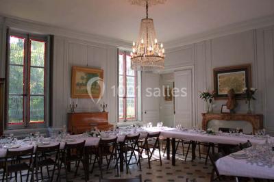 Façade d'un grand bâtiment ancien entouré de motos stationnées sur une pelouse et une allée gravillonnée.