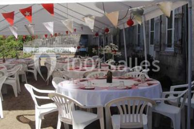 Façade d'un grand bâtiment ancien entouré de motos stationnées sur une pelouse et une allée gravillonnée.