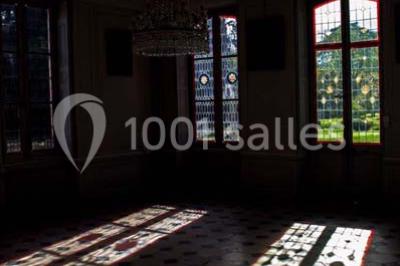 Façade d'un grand bâtiment ancien entouré de motos stationnées sur une pelouse et une allée gravillonnée.