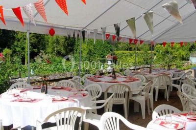 Façade d'un grand bâtiment ancien entouré de motos stationnées sur une pelouse et une allée gravillonnée.