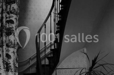 Façade d'un grand bâtiment ancien entouré de motos stationnées sur une pelouse et une allée gravillonnée.