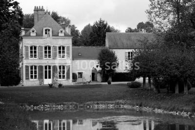 Façade d'un grand bâtiment ancien entouré de motos stationnées sur une pelouse et une allée gravillonnée.