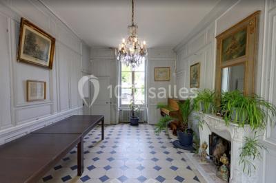 Façade d'un grand bâtiment ancien entouré de motos stationnées sur une pelouse et une allée gravillonnée.