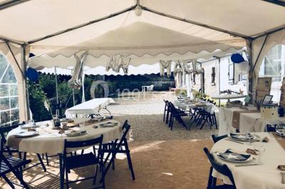 Façade d'un grand bâtiment ancien entouré de motos stationnées sur une pelouse et une allée gravillonnée.