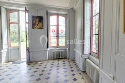 Façade d'un grand bâtiment ancien entouré de motos stationnées sur une pelouse et une allée gravillonnée.