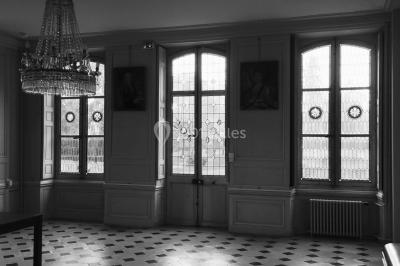 Façade d'un grand bâtiment ancien entouré de motos stationnées sur une pelouse et une allée gravillonnée.