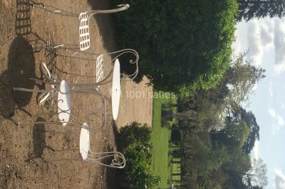 Façade d'un grand bâtiment ancien entouré de motos stationnées sur une pelouse et une allée gravillonnée.