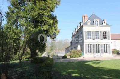 Un homme joue de l'orgue de barbarie tandis qu'une femme chante en plein air, entourés de verdure.