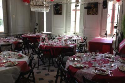 Un homme joue de l'orgue de barbarie tandis qu'une femme chante en plein air, entourés de verdure.