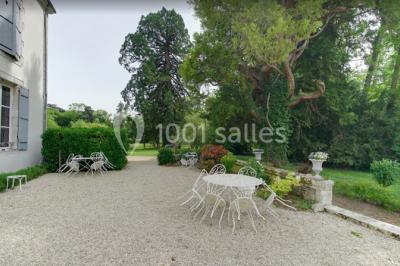 Un homme joue de l'orgue de barbarie tandis qu'une femme chante en plein air, entourés de verdure.