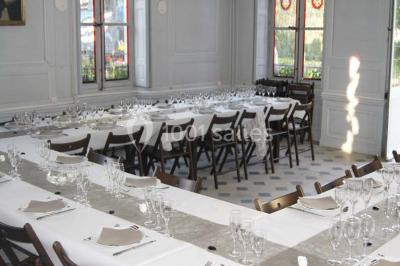 Un homme joue de l'orgue de barbarie tandis qu'une femme chante en plein air, entourés de verdure.