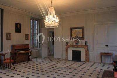 Un homme joue de l'orgue de barbarie tandis qu'une femme chante en plein air, entourés de verdure.