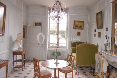 Un homme joue de l'orgue de barbarie tandis qu'une femme chante en plein air, entourés de verdure.