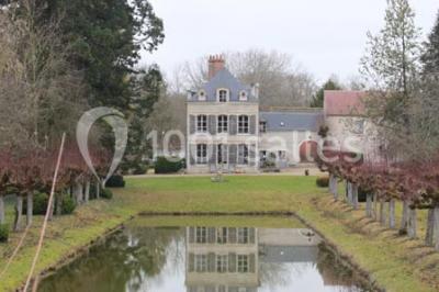 Un homme joue de l'orgue de barbarie tandis qu'une femme chante en plein air, entourés de verdure.