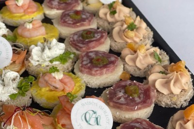 Petits plats individuels contenant purée, morceaux de viande en sauce et cuillères en bois, disposés sur un plateau.