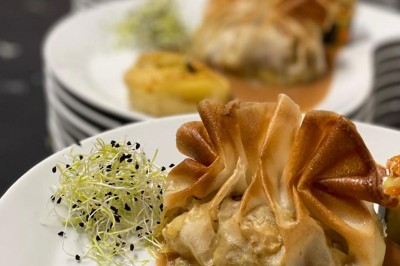 Petits plats individuels contenant purée, morceaux de viande en sauce et cuillères en bois, disposés sur un plateau.