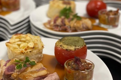 Petits plats individuels contenant purée, morceaux de viande en sauce et cuillères en bois, disposés sur un plateau.