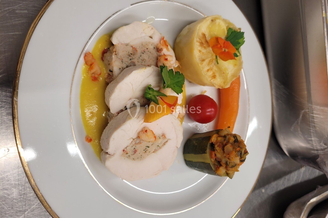 Assiette gastronomique avec roulé de volaille, garnitures de légumes, purée gratinée et sauce dressée.