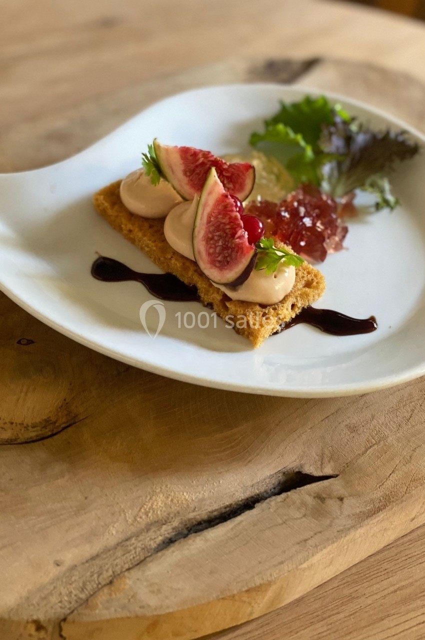 Dessert élégant composé de figues fraîches, mousse, gelée et salade verte, présenté sur une assiette blanche.