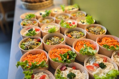 Petits plats individuels contenant purée, morceaux de viande en sauce et cuillères en bois, disposés sur un plateau.